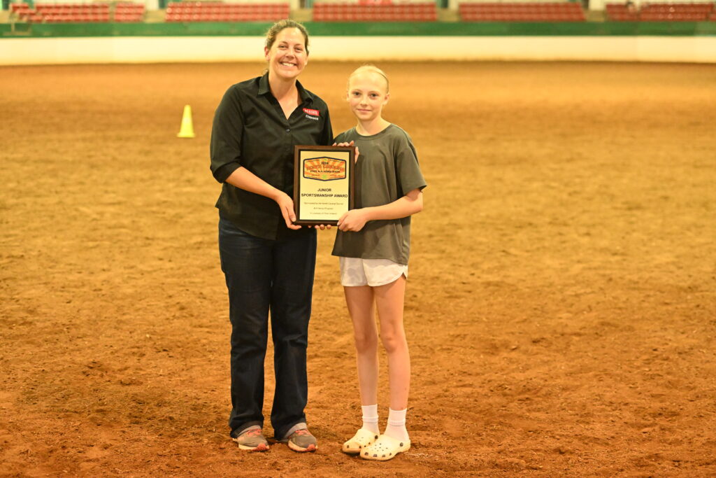 A girl is presented with an award in the middle of an arena.