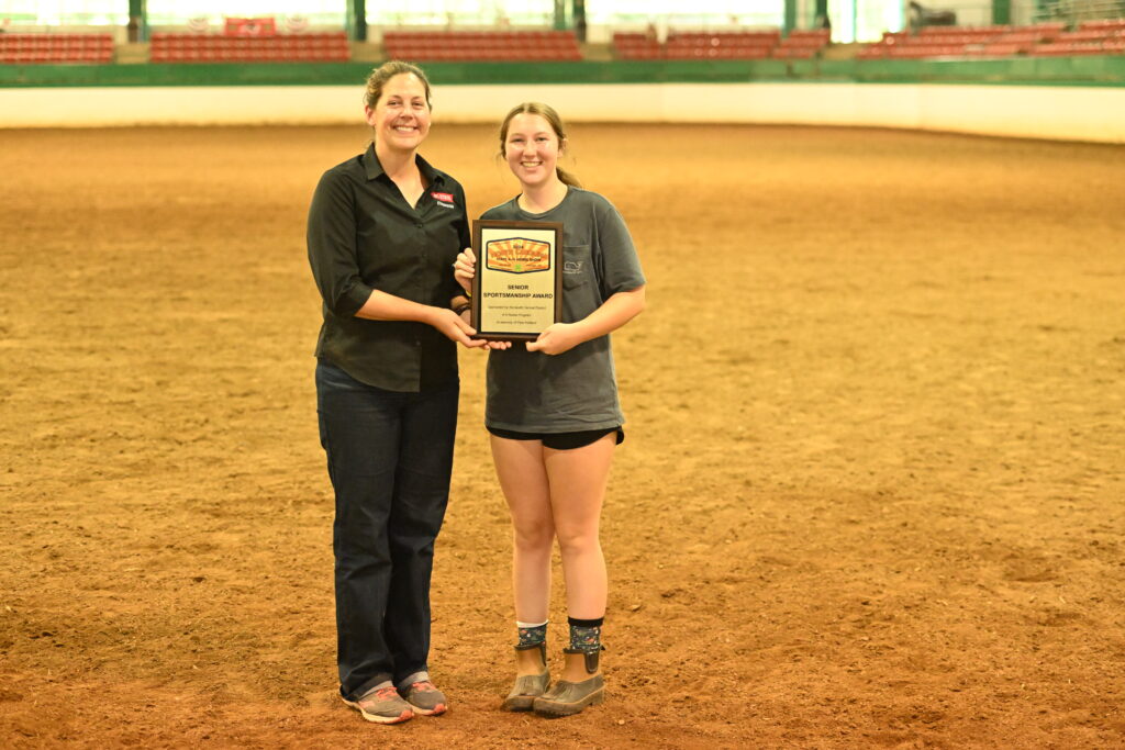 A girl is presented with an award in the middle of an arena.